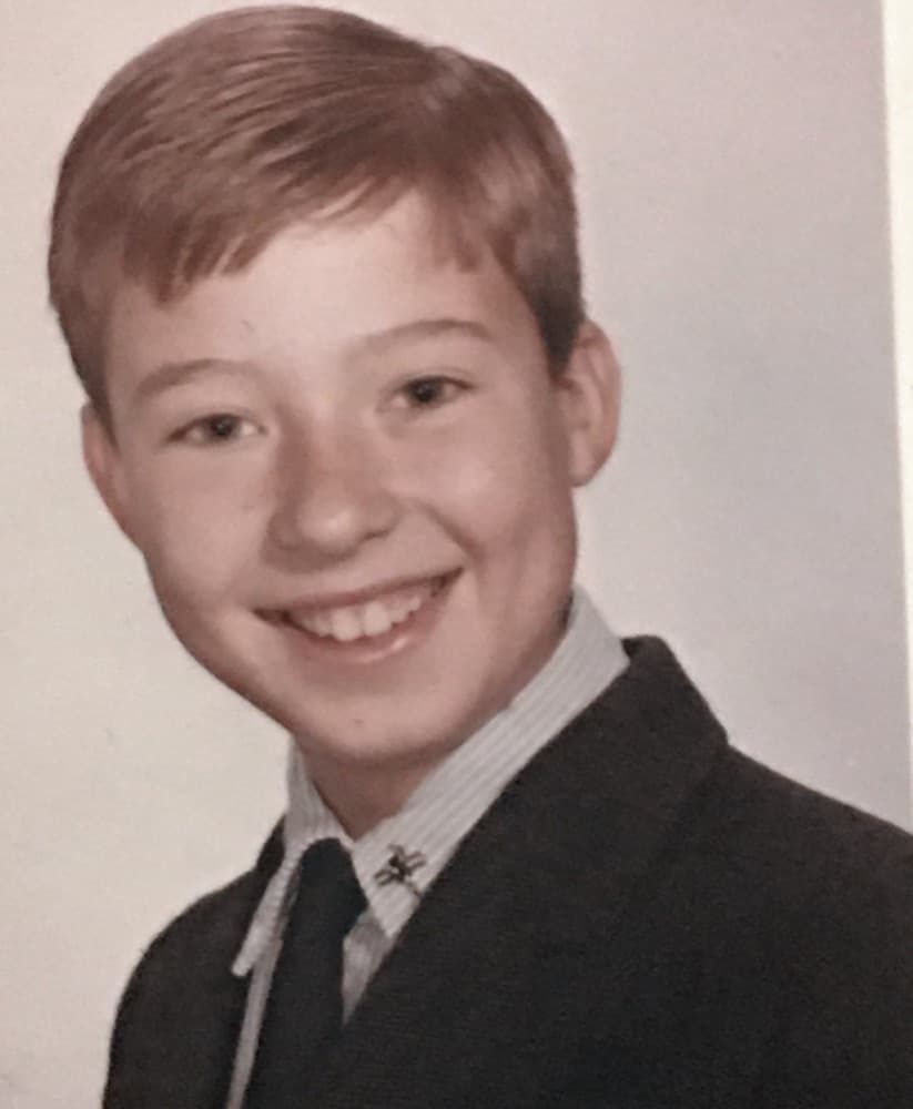 A vintage school portrait of a smiling boy in a dark blazer, striped shirt and tie.